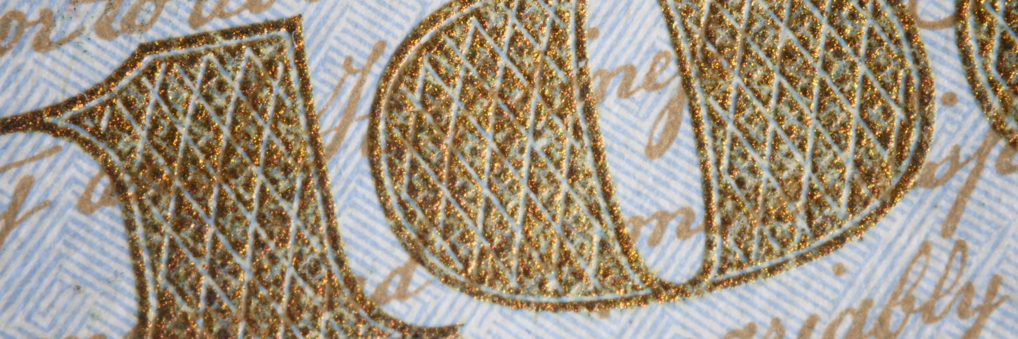 Close-up of hand embroidery on linen with gold threads